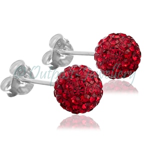 Può includere: Un paio di orecchini a lobo a sfera di cristallo rosso. Ogni orecchino presenta una sfera di piccoli cristalli rossi sfaccettati su un perno d'argento con chiusura a farfalla. Gli orecchini sono esposti su sfondo bianco.