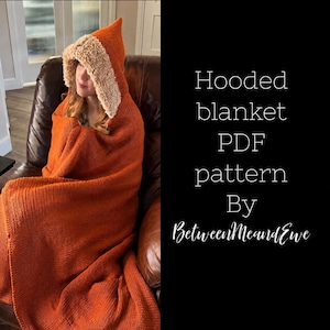 May include: A burnt orange hooded blanket with a textured cream-colored faux fur trim around the hood. The text on the right side reads: Hooded blanket PDF pattern By BetweenMeandEwe. The blanket is draped over the shoulders and covers the body.