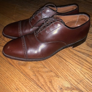 Peut inclure: Une paire de chaussures en cuir marron à lacets avec un bout captoe. Les chaussures ont une finition polie et sont faites de cuir de haute qualité.