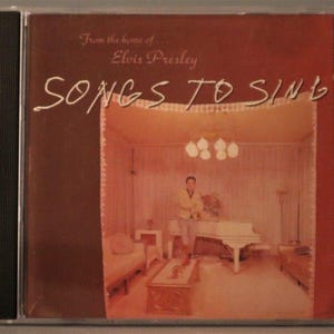 May include: A CD case with the album "Songs to Sing" by Elvis Presley. The cover art depicts a room with a white piano and a person in a yellow jacket. The text "From the home of Elvis Presley" is also visible.