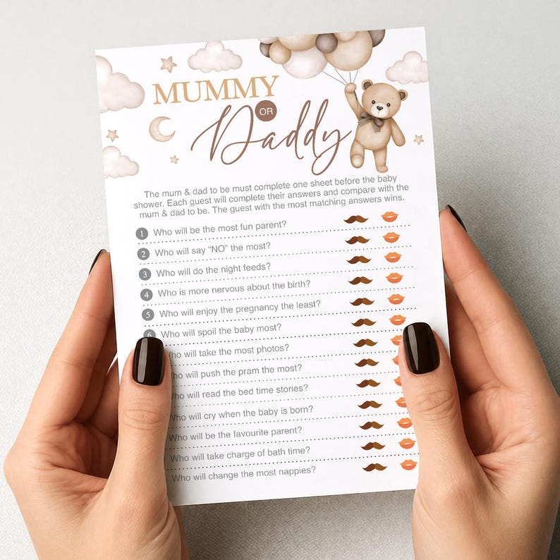 Op de afbeelding: Een babyshower-spelkaart met de tekst "Mummy or Daddy" en een teddybeer-illustratie. De kaart bevat vragen over de aanstaande ouders, met snor- en lipafbeeldingen om te beantwoorden. De kaart wordt door een persoon vastgehouden.