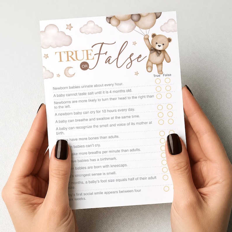 Op de afbeelding: Een babyshower-spelkaart met een illustratie van een teddybeer die ballonnen vasthoudt. De kaart bevat de tekst "Waar of Onwaar" en een reeks uitspraken over baby's. De kaart heeft een zacht, neutraal kleurenpalet met gouden accenten.