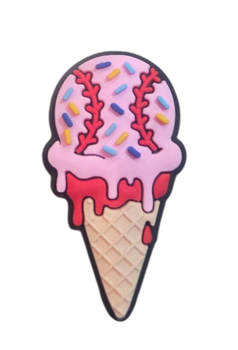 Pode incluir: Um berloque de cone de sorvete com tema de beisebol. O sorvete rosa tem costuras vermelhas e &eacute; decorado com granulado colorido. O cone &eacute; bege com um padr&atilde;o de waffle e um contorno preto.