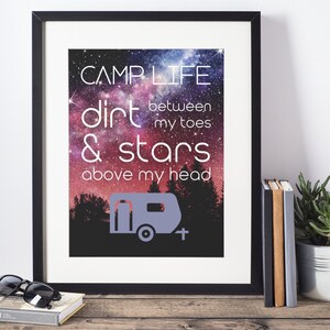 May include: A framed print with a galaxy background and the text "CAMPLIFE dirt between my toes & stars above my head". A small camper silhouette is in the bottom center of the print.