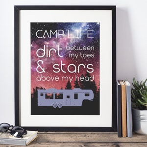 May include: A framed print with a galaxy background and a silhouette of a camper. The text reads "Camplife dirt between my toes & stars above my head."