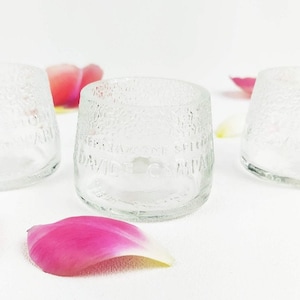 Könnte beinhalten: Drei klare Glasgefäße mit einer strukturierten Oberfläche. Die Gefäße tragen den Text "PERRAZZONE SPIG. DAVIDE & C. MILANO", der in das Glas geätzt ist.