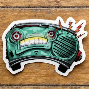 May include: A die-cut sticker featuring a teal, anthropomorphic vintage radio with a wide, toothy grin, two circular red-rimmed dials for eyes, and three jagged orange lightning bolts emanating from the top right corner of the speaker grille.