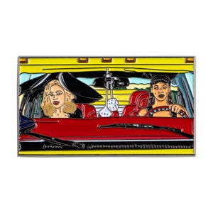 Può includere: Spilla smaltata raffigurante due donne in un'auto decappottabile rossa. L'auto ha un tetto giallo e interni neri. Una donna ha i capelli biondi e l'altra guida. La spilla ha un'estetica retrò e vintage.