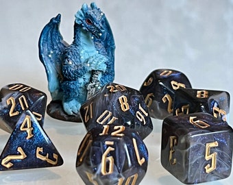 May include: A blue and white dragon figurine with a set of six black and gold dice with white swirls. The dice are numbered 1 through 6.