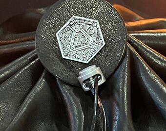 May include: A black leather dice bag with a silver metal D20 die charm. The bag has a drawstring closure and a silver metal clasp.