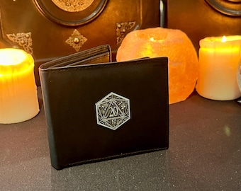 May include: A black leather wallet with a silver metal 20-sided die design. The die is engraved with the number 20.
