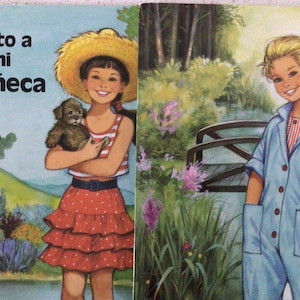 May include: Two book covers with illustrations. The left cover shows a girl in a straw hat holding a puppy, with the text "Visto a mi muñeca." The right cover depicts a girl in a blue jumpsuit near a bridge.