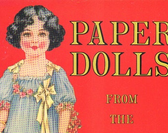 May include: A vintage-style paper doll book cover with a red background. The cover features a girl with dark hair wearing a blue dress with a yellow bow. The text "PAPER DOLLS FROM THE" is printed in yellow letters on the cover.