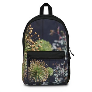 May include: Black backpack with a floral print featuring a close-up of a green and brown flower with a dark blue background.