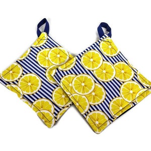 May include: Two blue and white striped pot holders with a lemon print. The pot holders have a loop handle.