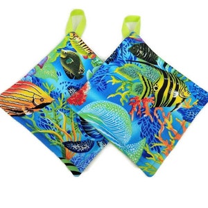 May include: A pair of blue and green pot holders with a colorful tropical fish and coral reef design. The pot holders have lime green loops for hanging.