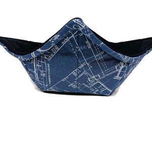 Puede incluir: Un bol de tela azul con un patrón de plano arquitectónico blanco. El bol está forrado con tela negra.