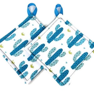 May include: Two blue and green cactus patterned pot holders with blue ribbon loops.