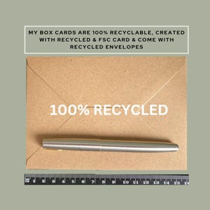 May include: A silver pen rests on a brown envelope with the text "100% RECYCLED". The envelope is on a green background. The text "MY BOX CARDS ARE 100% RECYCLABLE, CREATED WITH RECYCLED & FSC CARD & COME WITH RECYCLED ENVELOPES" is at the top.