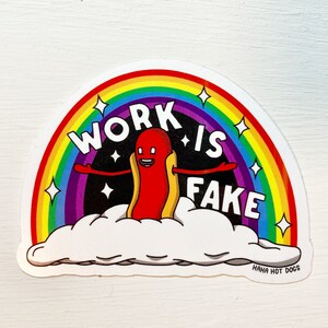 May include: A sticker with a rainbow background and a hot dog character with arms and legs. The hot dog is wearing a yellow bun and is sitting on a cloud. The text "WORK IS FAKE" is written in white letters on the sticker. The text "HAHA HOT DOGS" is written in white letters at the bottom of the sticker.