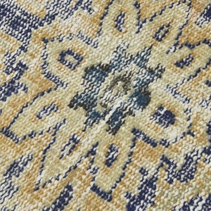 May include: Close-up of a woven rug with a geometric pattern in shades of blue, beige, and white.