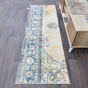 Op de afbeelding: Een vintage stijl loper met een blauw en cr&egrave;me bloemenpatroon. De loper heeft een verweerde look en is perfect om een ​​bohemien stijl aan je huis toe te voegen.