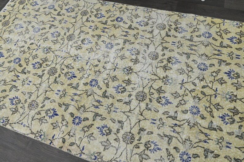 May include: A vintage rug with a cream background and a floral pattern in shades of blue and gray.