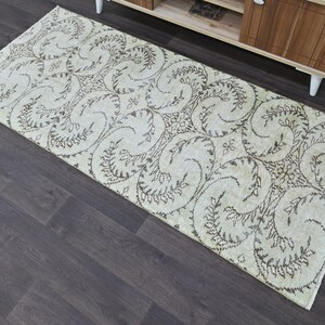 May include: A beige and brown patterned rug with a floral design. The rug is rectangular and has a fringed edge.