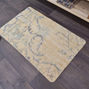 K&ouml;nnte beinhalten: Ein hellbeiger Teppich mit einem blauen und wei&szlig;en Muster. Der Teppich hat einen Used-Look und ist aus einem weichen, gewebten Material.