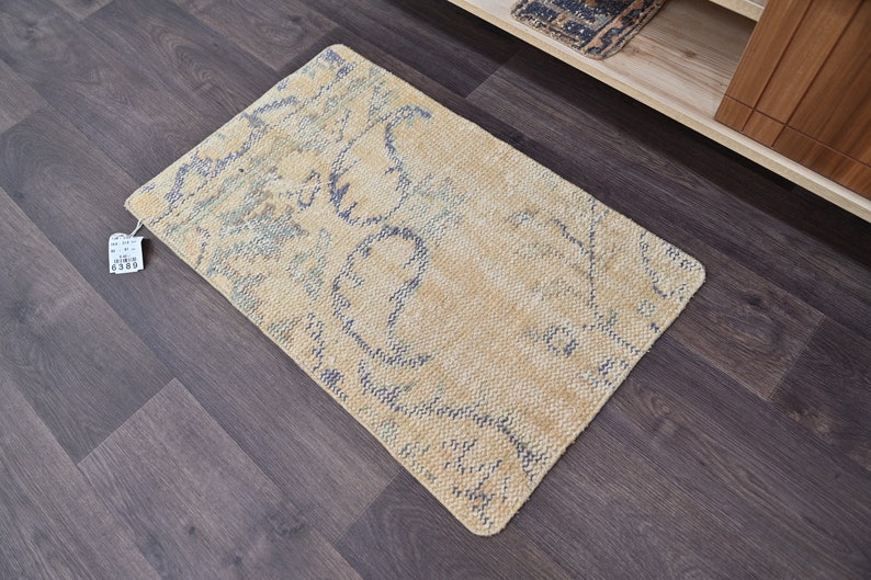 K&ouml;nnte beinhalten: Ein hellbeiger Teppich mit einem blauen und wei&szlig;en Muster. Der Teppich hat einen Used-Look und ist aus einem weichen, gewebten Material.