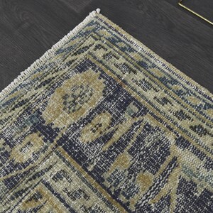 May include: A blue and beige patterned rug with a fringe border. The rug has a traditional design with intricate details.