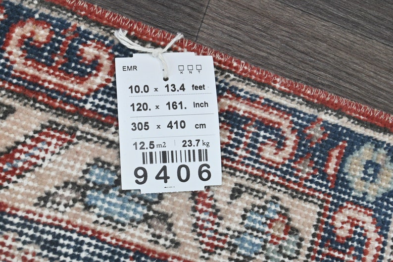 Pode incluir: Uma etiqueta branca com texto preto e um c&oacute;digo de barras. A etiqueta lista as dimens&otilde;es de um tapete em p&eacute;s, polegadas e cent&iacute;metros. O tapete mede 10 p&eacute;s por 13,4 p&eacute;s, 120 polegadas por 161 polegadas e 305 cent&iacute;metros por 410 cent&iacute;metros. A etiqueta tamb&eacute;m lista a &aacute;rea do tapete como 12,5 metros quadrados e seu peso como 23,7 quilogramas. O n&uacute;mero do c&oacute;digo de barras &eacute; 9406.