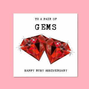 May include: A greeting card featuring a red ruby gemstone design. The card reads "To a pair of Gems Happy Ruby Anniversary".