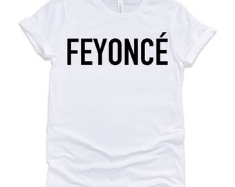 Può includere: Maglietta bianca con testo nero che dice "FEYONCÉ"