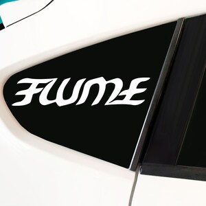 May include: A white car with a black window. The window has a white sticker that says "FUME" in a stylized font.