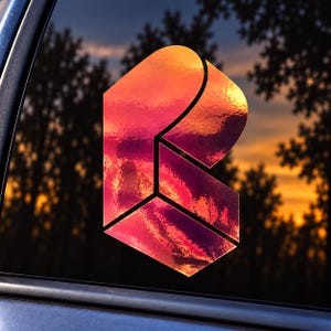 May include: A reflective, holographic decal in the shape of a stylized letter R, featuring a gradient of orange, pink, and purple hues. The design has a three-dimensional appearance with sharp geometric angles and clean, dark dividing lines.