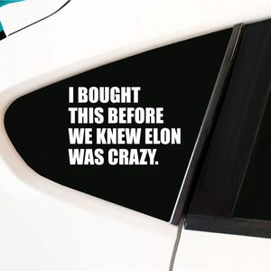 May include: A black and white car window sticker with the text "I bought this before we knew Elon was crazy."