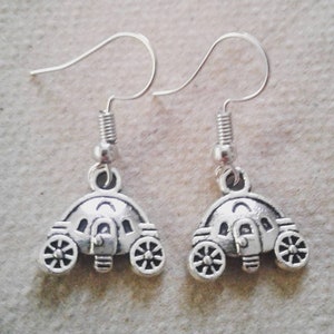 May include: A pair of silver earrings featuring a carriage design. The earrings are made of metal and have a hook closure.