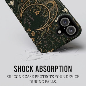 K&ouml;nnte beinhalten: Eine dunkelgr&uuml;ne Handyh&uuml;lle mit einer goldenen Mondsichel und botanischen Illustrationen von Blumen und Bl&auml;ttern. Der Text SHOCK ABSORPTION und SILICONE CASE PROTECTS YOUR DEVICE DURING FALLS steht unter der H&uuml;lle.