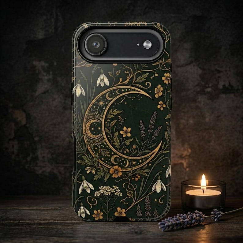 K&ouml;nnte beinhalten: Eine dunkelgr&uuml;ne Smartphone-H&uuml;lle mit einer goldenen Mondsichel-Illustration, umgeben von komplizierten botanischen Mustern, darunter wei&szlig;e Schneegl&ouml;ckchen, kleine gelbe Blumen und Lavendelzweige.