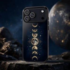 Könnte beinhalten: Eine schwarze Smartphone-Hülle mit einer vertikalen Abfolge goldener Mondphasen vor einem dunkelblauen Hintergrund. Das Design umfasst komplexe himmlische Sternenmuster und feine Linien, die die detaillierten Mondabbildungen umgeben.