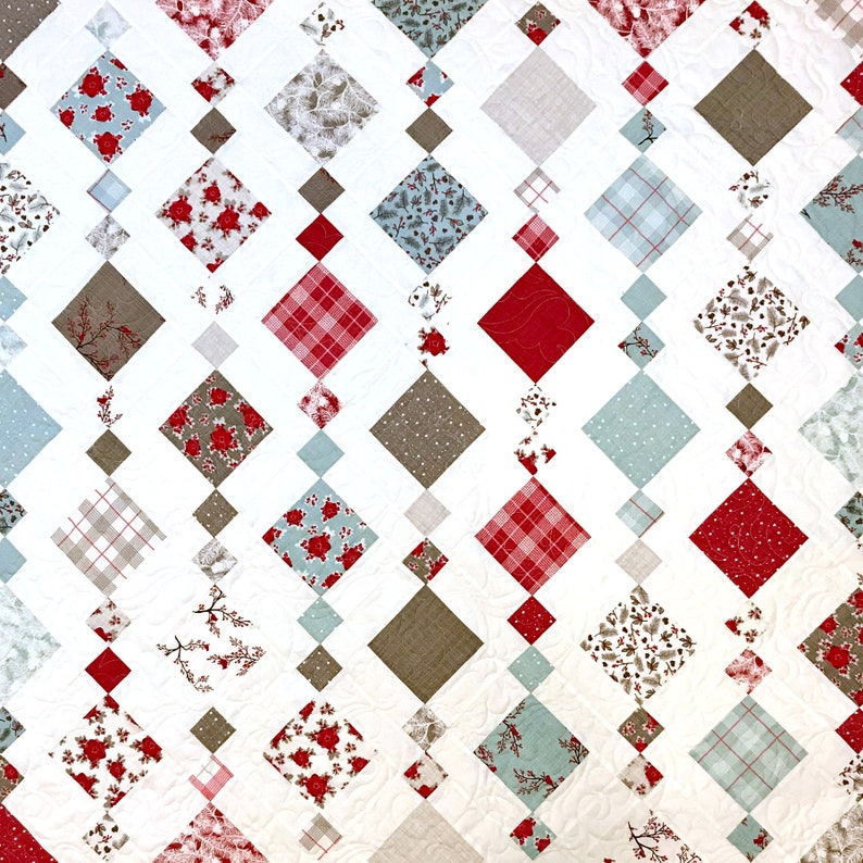 May include: A white quilt with a diamond pattern made from various fabrics. The fabrics include red, blue, brown, and white plaid patterns. The quilt is made with a variety of floral and geometric prints.