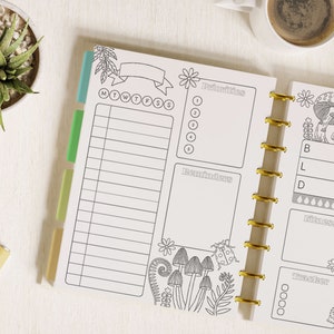 May include: A disc-bound planner insert featuring black and white line art with mushroom and floral motifs. The layout includes sections for priorities, reminders, a daily schedule, and trackers for meals, fitness, and habits with labeled headers.