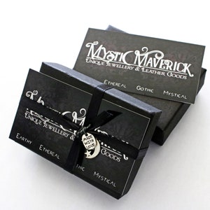 May include: Black boxes with the text "Mystic Maverick Unique Jewellery & Leather Goods" in white. The boxes are tied with a black ribbon and a charm that says "Made with Love". The boxes have the words "Earthy, Ethereal, Gothic, Mystical".