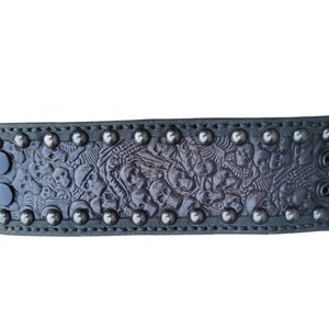 May include: A black leather bracelet with a skull pattern and silver studs.
