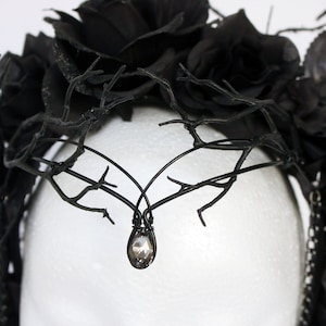 May include: Black floral crown with black branches and a crystal teardrop pendant.