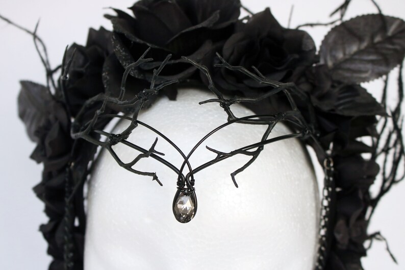 May include: Black floral crown with black branches and a crystal teardrop pendant.