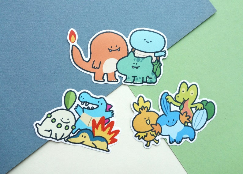 May include: A set of nine cartoon character stickers featuring various Pokemon characters, including Bulbasaur, Charmander, Squirtle, and others. The stickers are printed on white paper and have a glossy finish.