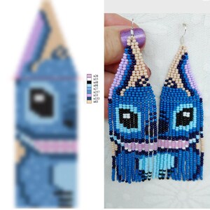May include: Handmade beaded earrings in a cartoon character design. The earrings are primarily blue, with black, pink, and beige accents. They have a fringed bottom and are suspended from silver hooks. The design is symmetrical.