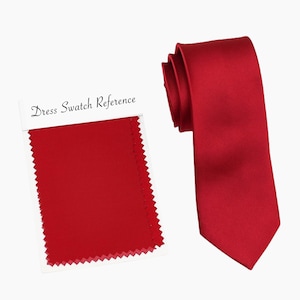 Può includere: Una cravatta di raso rosso con un campione di tessuto abbinato etichettato "Dress Swatch Reference".